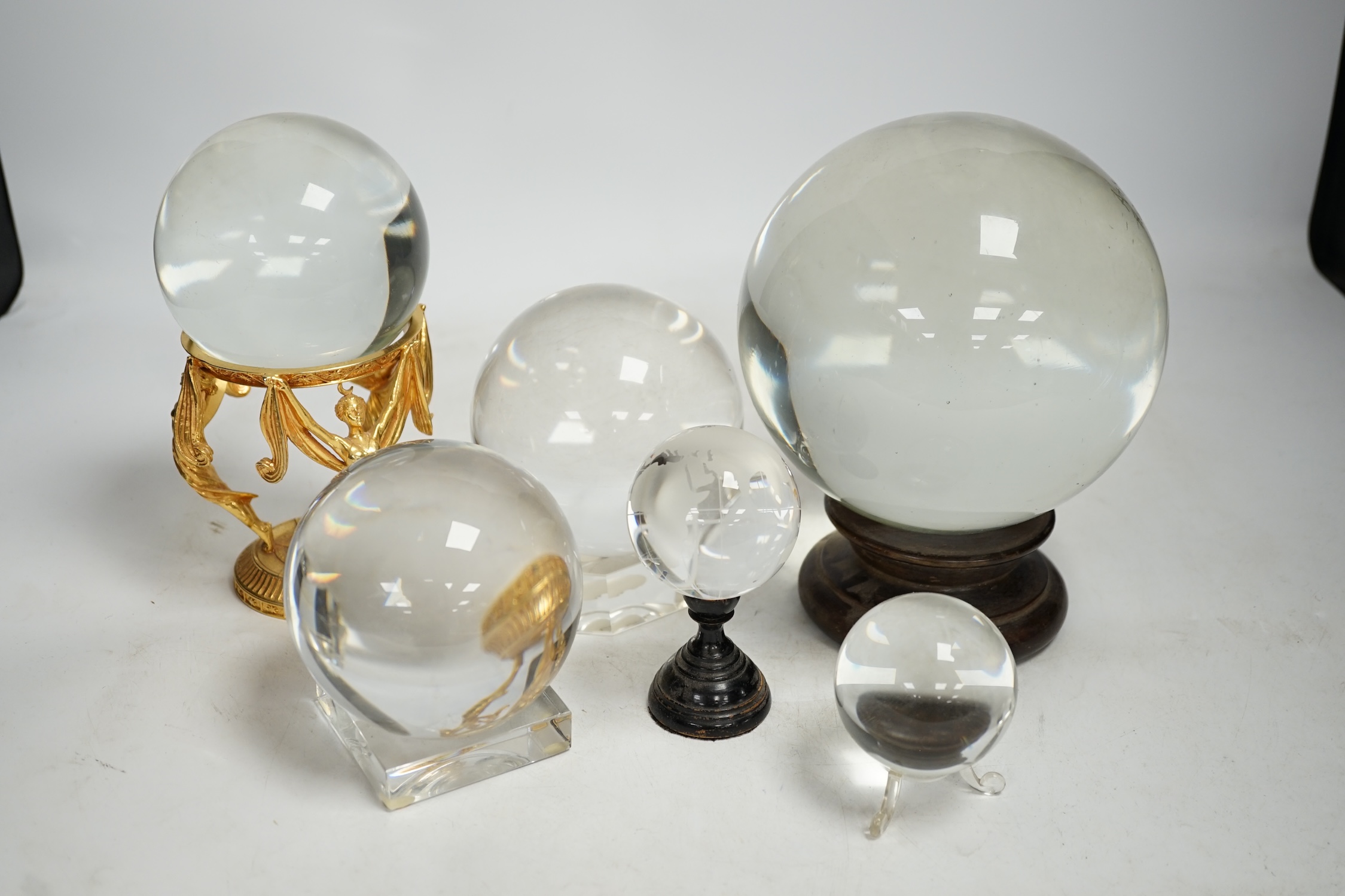 A group of six crystal balls on stands, largest 14cm across. Condition - fair